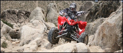 Colby Kostman climbing through a rock field on the Polaris Outlaw 525 S